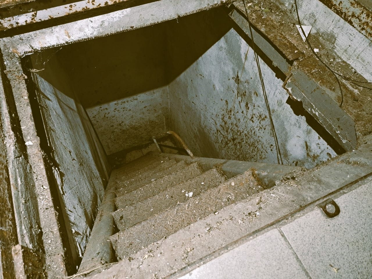 The staircase leading to the boiler room on the airport territory, where interrogations and torture of prisoners were conducted. Marks from fingernails and absorbed blood are visible on the walls (Photo – Andrey Zhuravlev)